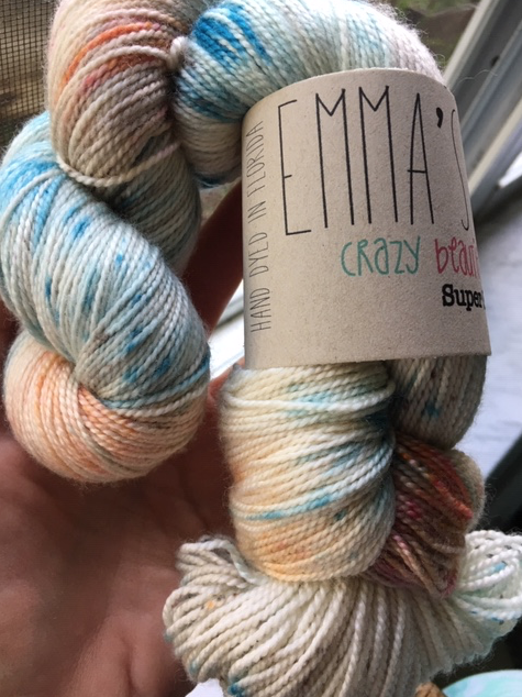 Farmers Market yarn skein is variegated blue, peach, teal, yellow-green and white.