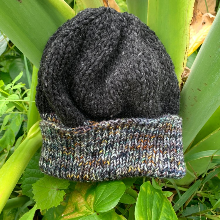 Hand knitted winter hat in a tropical elephant ear plant