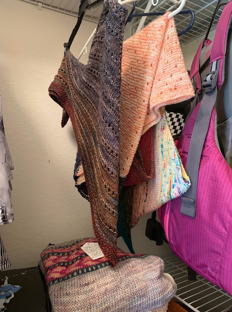 hand knit shawls hanging in closet