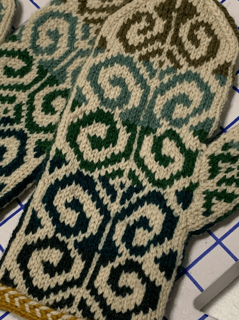 Hand knit green fiddlehead mittens pattern