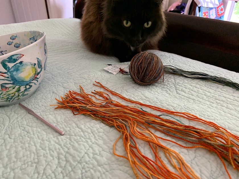 Cutting yarn for fringe as Fontana watches