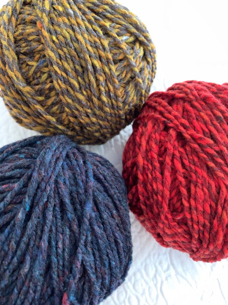 Brooklyn Tweed Shelter yarn in colors Old World, Amaranth, and Caraway