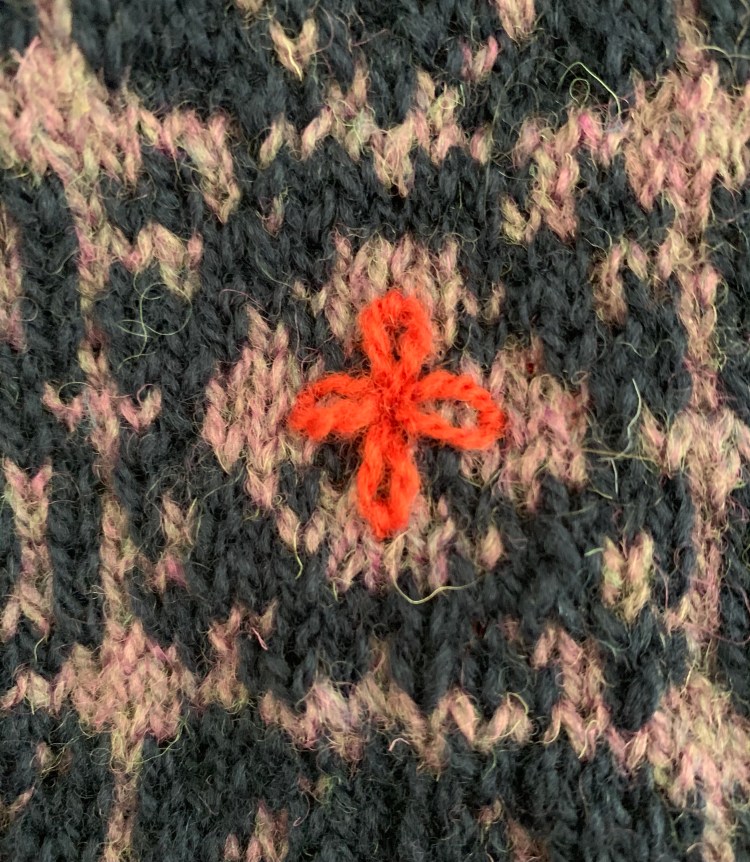 Simple Lazy Daisy embroidery flower on knitting