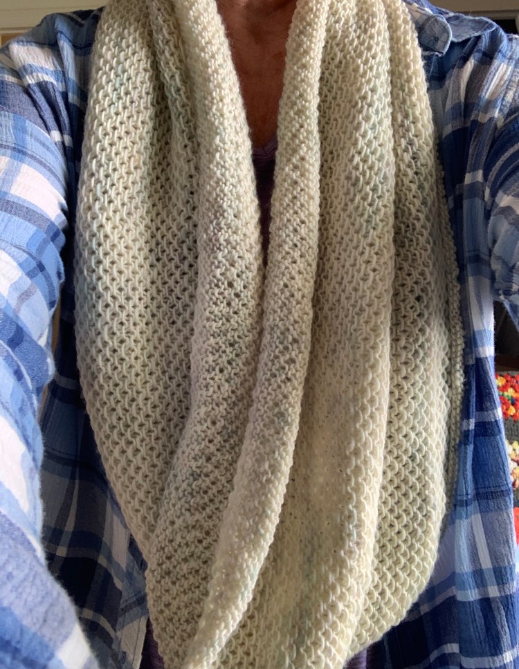 Honey cowl knit using fingering weight yarn in long infinity scarf project.