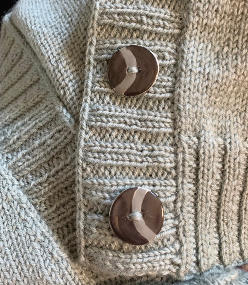 sewing buttons on a sweater