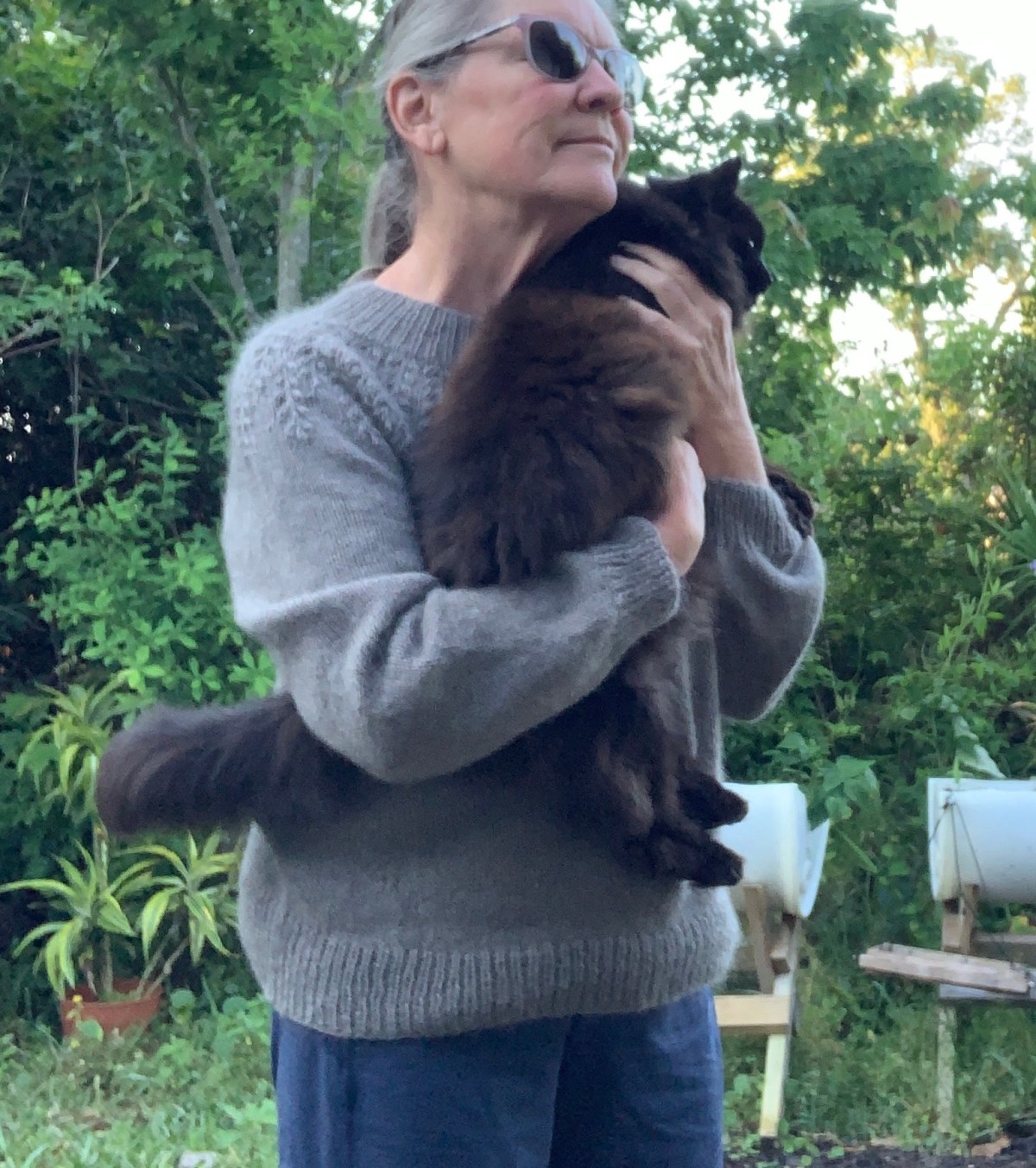 wearing hand knit Field sweater holding black cat
