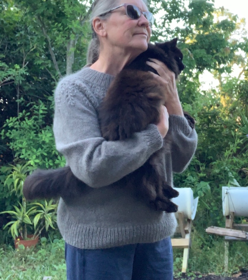 wearing hand knit Field sweater holding black cat